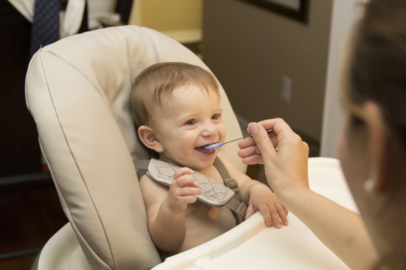 ein Baby wird mit Brei gefüttert.