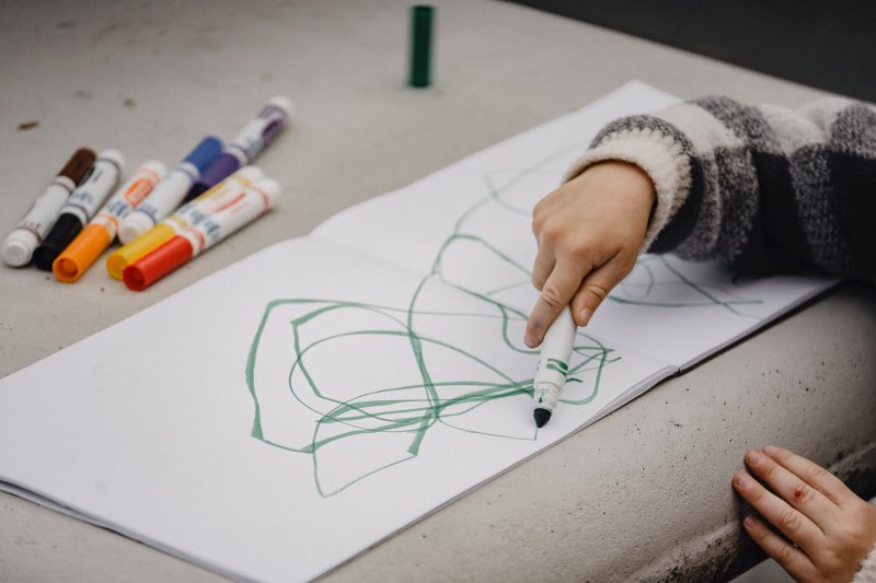 Ein Kind malt mit Filzstiften.