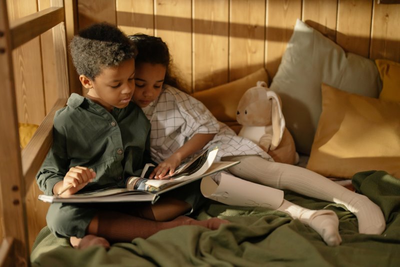 zwei Kinder lesen gemeinsam ein Buch
