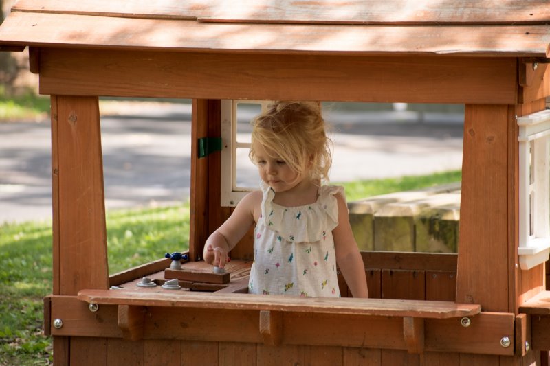 Ein Mädchen spielt in einem offenen Spielhaus