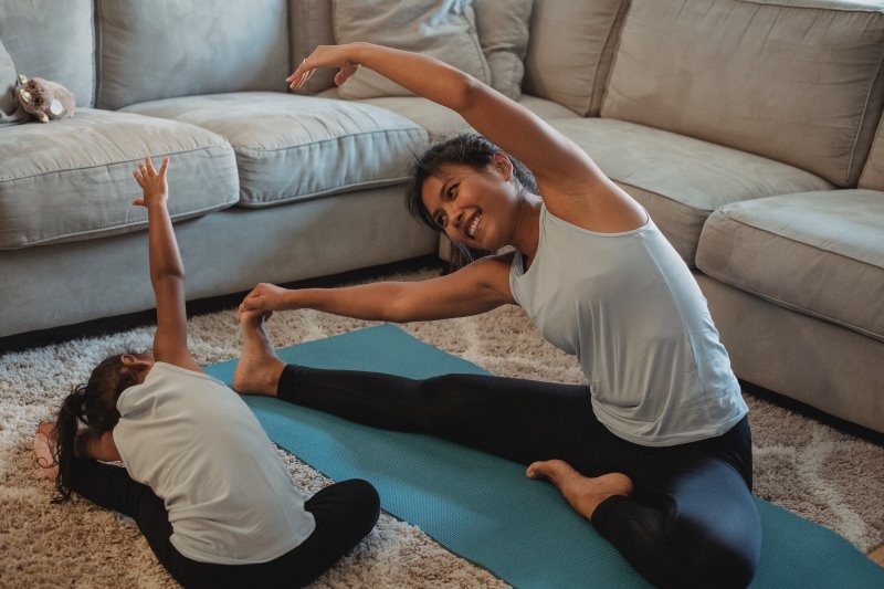 Mutter und Kind machen Yoga in derselben Sportbekleidung