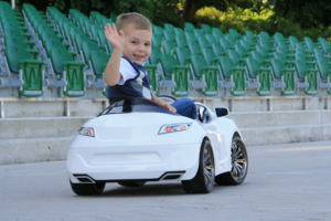 Ein Kind auf einem Kinder-Elektroauto.