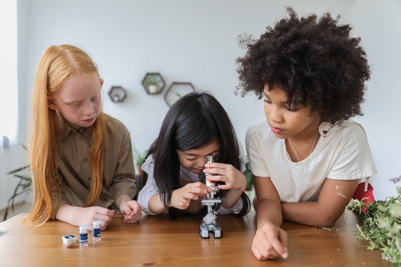Kinder schauen durch ein Mikroskop