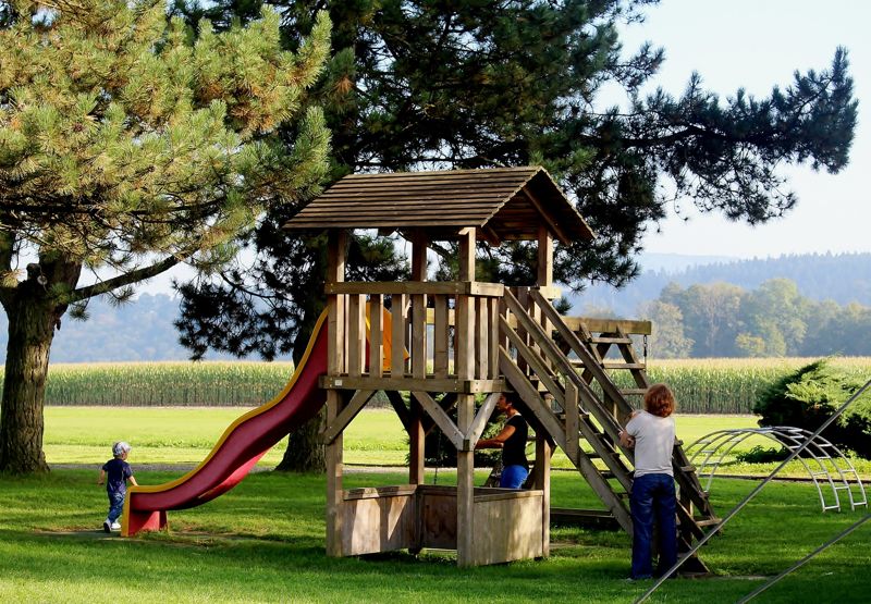 Spielturm mit Kindern auf einer Rasenfläche