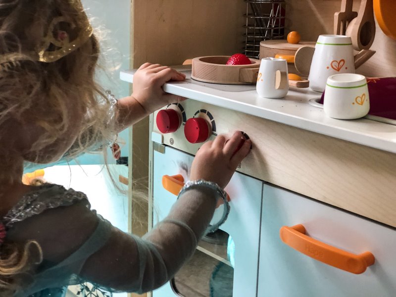 Holz Kinderküche Kind spielt in einem Kostüm in einer Kinderküche