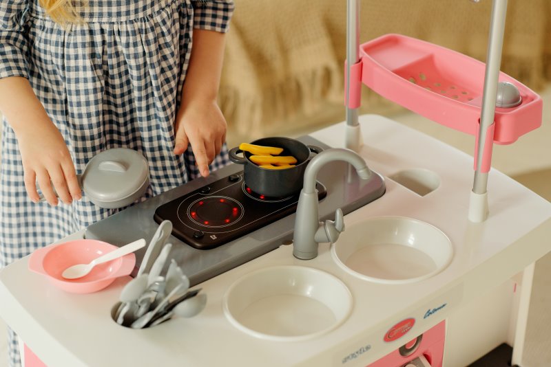 Kinderküche Funktionen Kind spielt mit dem Herd von einer Kinderküche