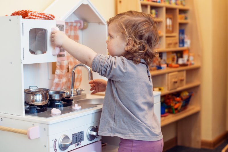 Kind spilet in einer Kinderküche