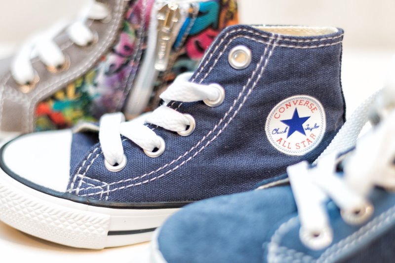 Kleine Kinder-Sneaker stehen nebeneinander in unterschiedlichen Designs