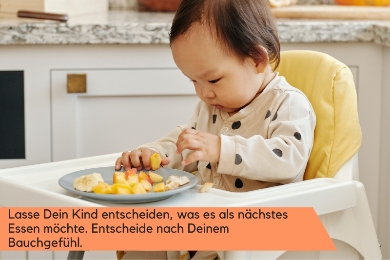 Babybrei Baby spielt mit dem Essen auf seinem Teller.