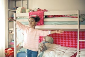 Ein Mädchen steht vor einem Hochbett