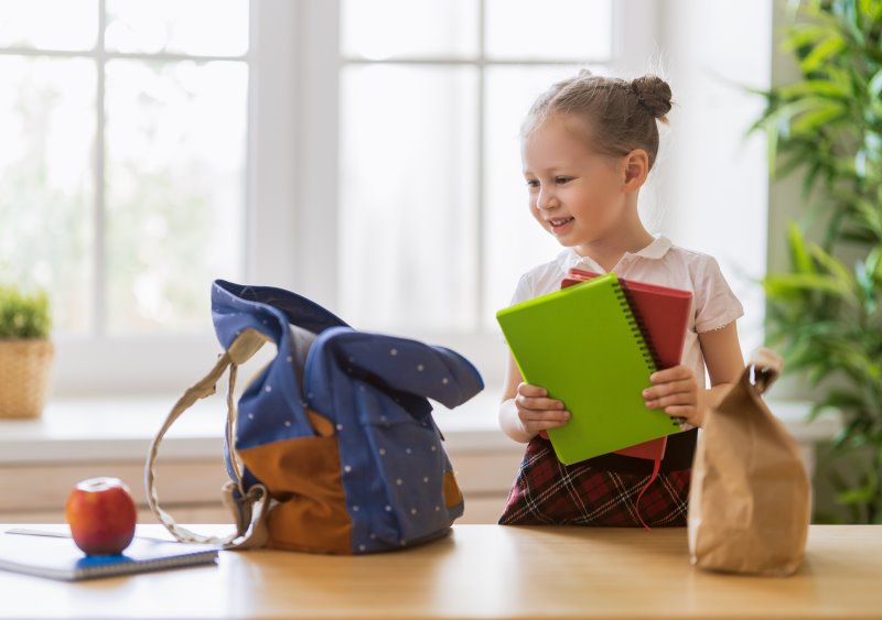 ein Kind bereitet sich auf die Schule vor Ein Kind möchte Bücher in eine Tasche packen.