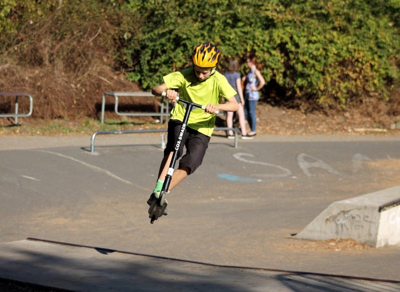 Ein Junge fährt mit einem Stunt-Scooter