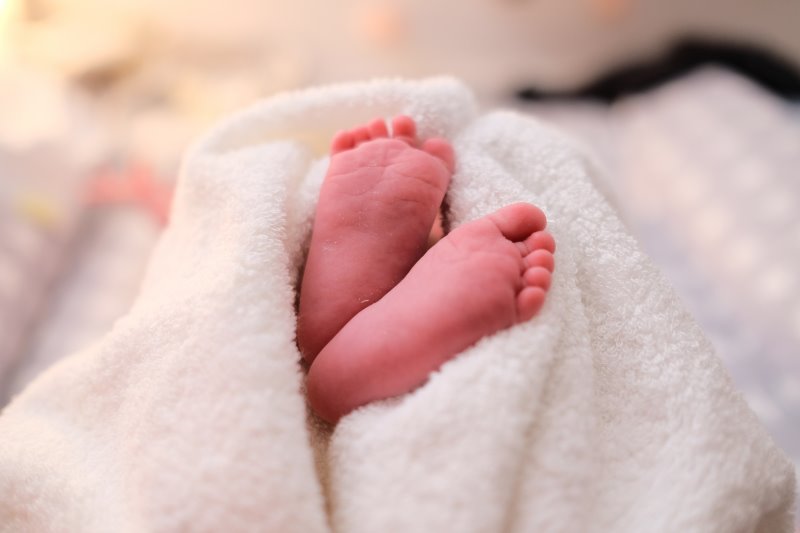 Baby-Badetuch Babyfüße im Badetuch Babyfüße sind in einem Badetuch eingewickelt.