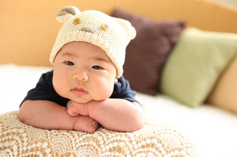 Baby mit Strickmütze Baby mit Wintermütze aus Stick mit Ohren und Gesicht