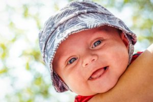 Ein lachendes Baby mit einem Sonnenhut