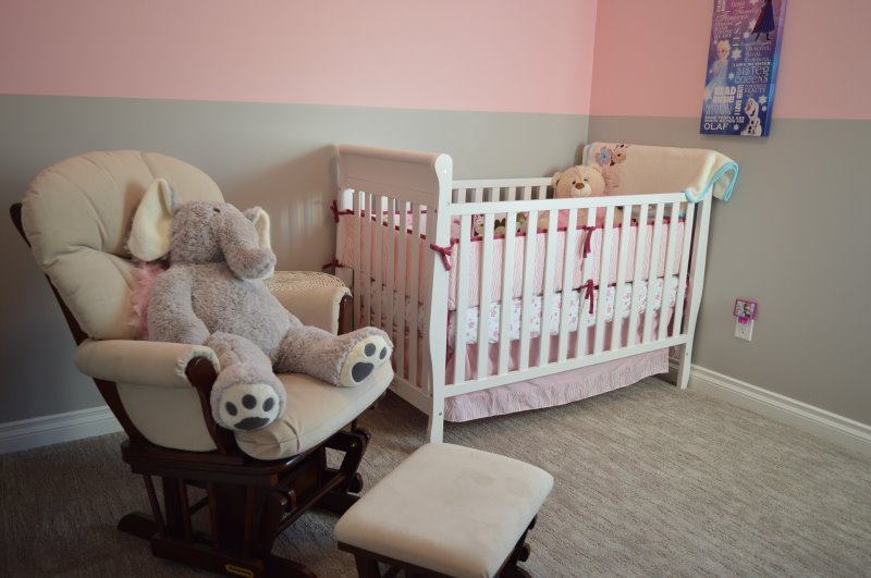 Ein Stoff-Elefant auf einem gepolsterten Stuhl im Babyzimmer Ein Schaukelstuhl oder ein bequemer Sessel darf im Babyzimmer nicht fehlen