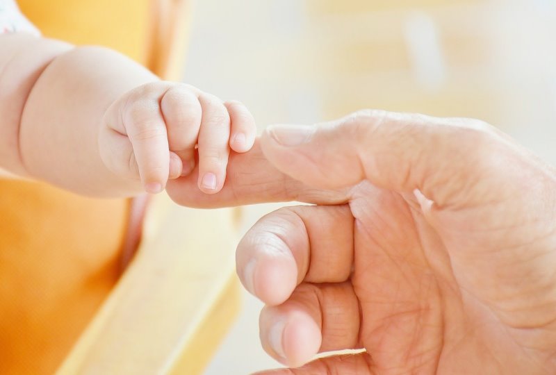 Vaporisator kaufen Hand eines Erwachsenen und eines Babys