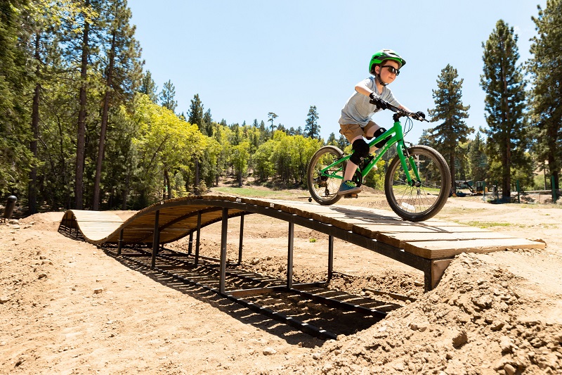Kind fährt auf der Rampe im Bikepark