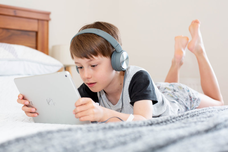 Junge schaut mit Kinderkopfhörern auf dem Tablet einen Film Junge schaut mit Kinderkopfhörern auf dem Tablet einen Film