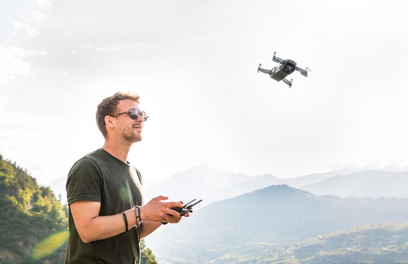 Ein Mann mit Drohne Wenn Kinder mit Drohnen fliegen, sollte immer eine erwachsene Aufsichtsperson anwesend sein.