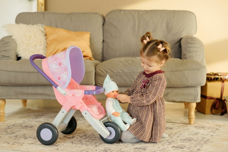 Puppe Puppenwagen Mädchen spielt mit einer Puppe und einem Puppenwagen