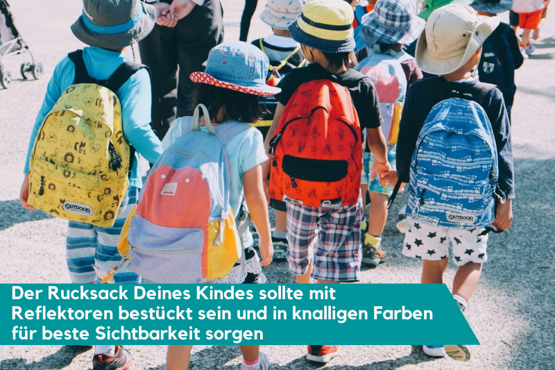 Gruppe von Schulkindern mit Schulrucksack überquert eine Straße