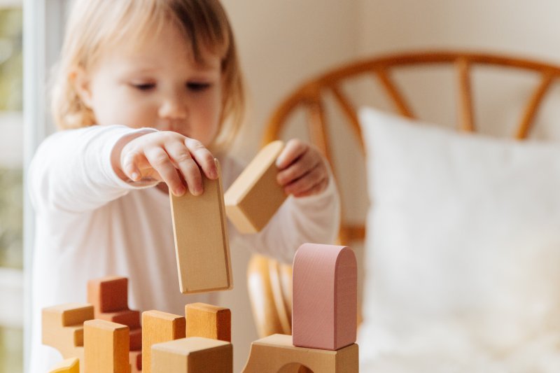 Kind stapelt Holzspielzeug Kind das Holzspielzeug stapelt