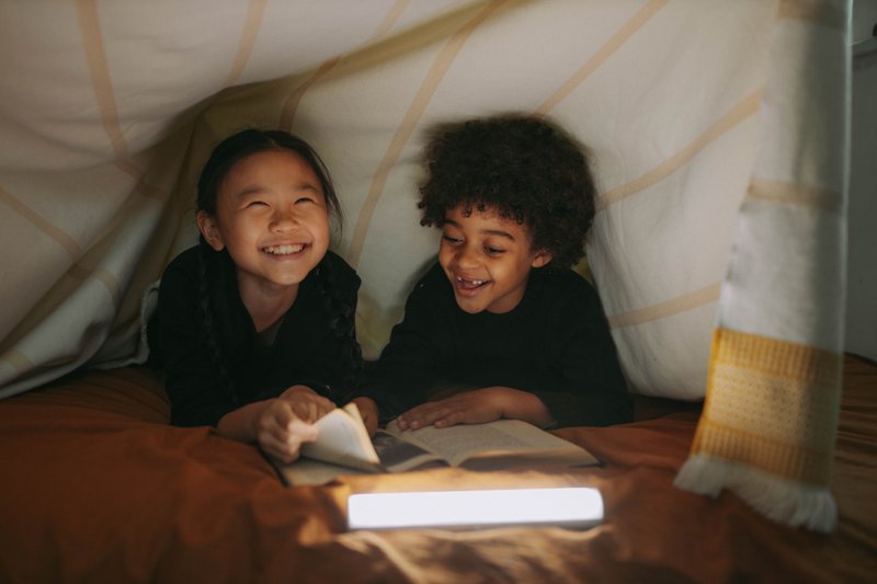 Kinder lesen ein Buch Zwei Kinder lesen ein Kinderbuch