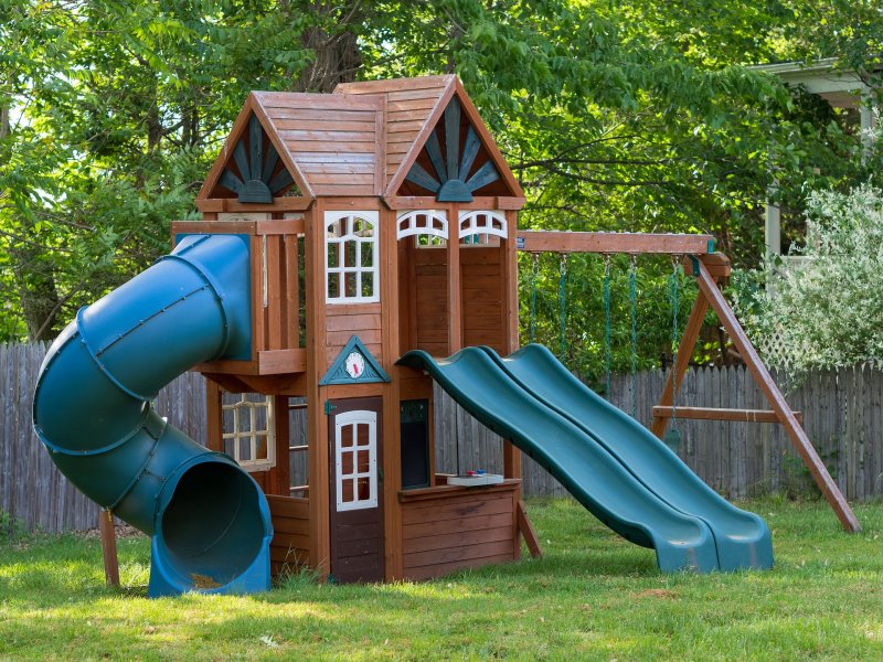 Kinder-Spielhaus Ausstattung Ein Spielhaus mit Rutschen und Schaukeln
