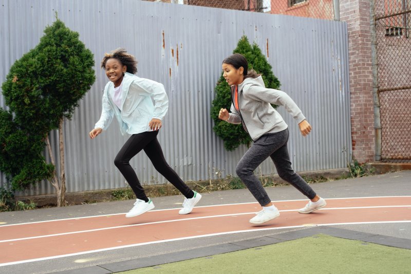 Laufen mit Kinder-Sportbekleidung Zwei Mädchen laufen in Sportsachen