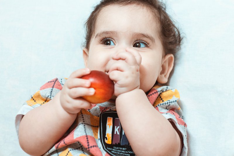 Bild isst Obst und lacht Kind ist glücklich wenn es Obst ist aber andere möchten eventuell was anderes
