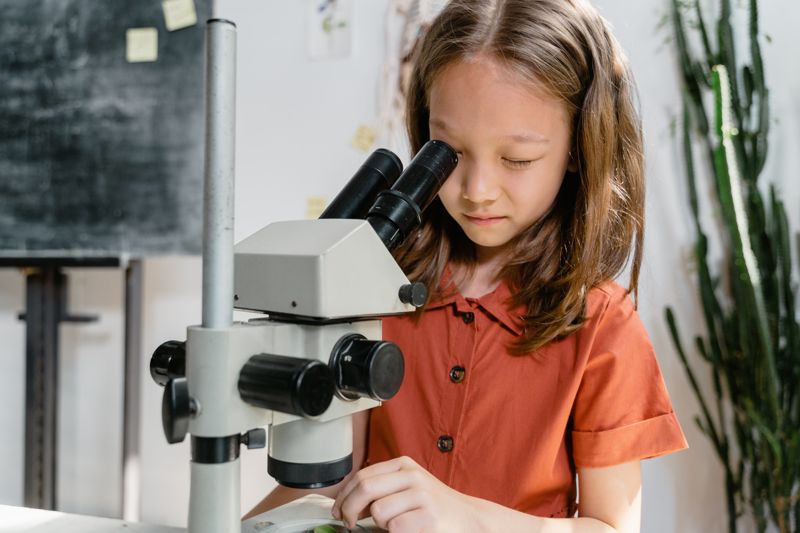 Kind analysiert eine Probe Ein Kind analysiert eine Probe in der Schuule