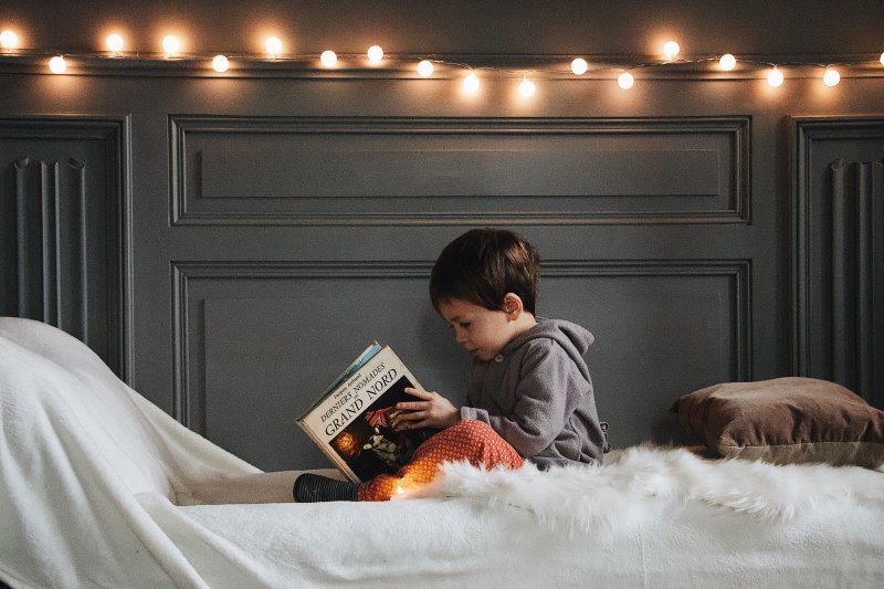 Junge ließt Kinder-Weihnachtsbuch Junge ließt Weihnachtsbuch im Bett